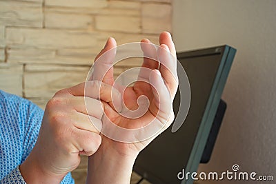 Concept photo of pain or spasm in thumb. Man hold thumb with palm of the other hand, which muscles of which are spasming or aching Stock Photo