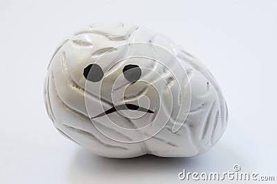 Concept photo of unhappy, sad brain with sickness disorder. Model of brain with sad smile, which symbolizes neurologic problem: di Stock Photo