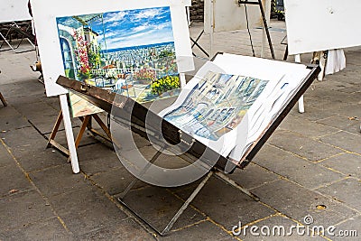 Opened easel briefcase with work of a street artist inside. Exhibition where painters sell their paintings Editorial Stock Photo