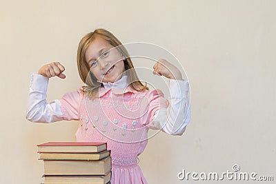 Concept The power of knowledge. A girl with a pile of books shows her strength. Education concept. copy space Stock Photo