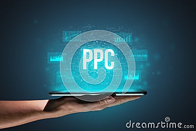 Concept PPC or Pay per click. Business acronym. Holographic icons and text over tablet in hands Stock Photo