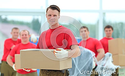 Foreman and workers with boxes of building materials Stock Photo
