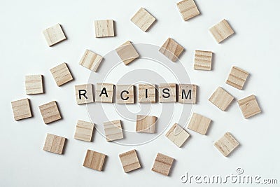 Concept of racism and misunderstanding between people, prejudice and discrimination. Wooden block with word racism on the white Stock Photo