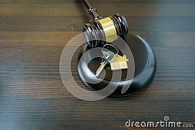 Concept of real estate auction, legal system and division of property after divorce. Gavel and house key on a wooden background Stock Photo