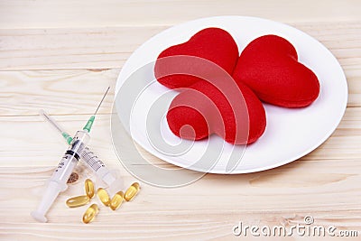 Concept red heart on plate with syringe and stimulant on wood b Stock Photo