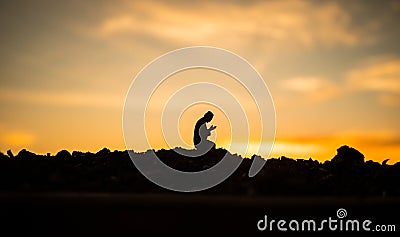 Concept of religion Islam. Silhouette of man praying on the background of a mosque at sunset Stock Photo