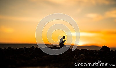 Concept of religion Islam. Silhouette of man praying on the background of a mosque at sunset Stock Photo