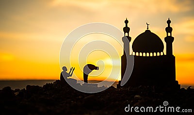 Concept of religion Islam. Silhouette of man praying on the background of a mosque at sunset Stock Photo