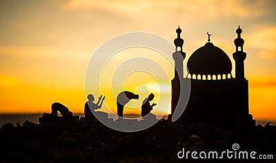 Concept of religion Islam. Silhouette of man praying on the background of a mosque at sunset Stock Photo