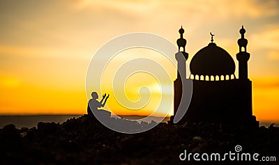 Concept of religion Islam. Silhouette of man praying on the background of a mosque at sunset Stock Photo