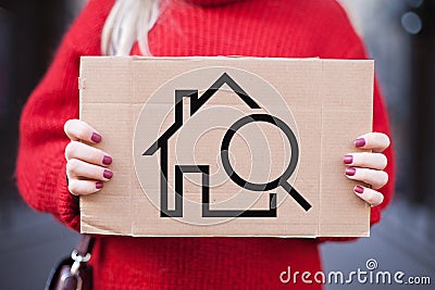 The concept of rent, search, purchase of real estate. Plate with the image of a house in the hands of a girl Stock Photo