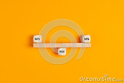 Concept of risk analysis or risk sharing in business. Wooden blocks designed as a seesaw balanced with the risk distribution of 50 Stock Photo