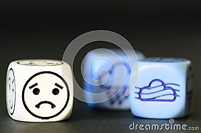 concept of sad autumn weather - emoticon and weather dice on black background Stock Photo