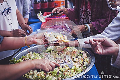 The concept of sharing food to hungry and starving people : Volunteers are handing out food to the poor Stock Photo