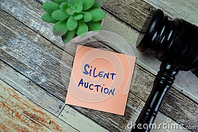 Concept of Silent Auction write on sticky notes with Gavel isolated on Wooden Table Stock Photo