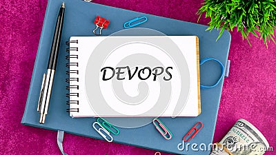 Concept for software engineering culture and practice of software development. DEVOPS word in a mini notebook on a Stock Photo