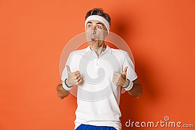 Concept of sport, fitness and lifestyle. Portrait of amazed and excited middle-aged sportsman, looking at upper left Stock Photo