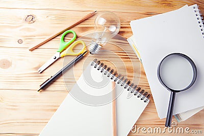 Magnifier, notepad, lamp and pen on the desktop Stock Photo