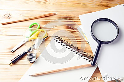 Magnifier, notepad, lamp and pen on the desktop Stock Photo