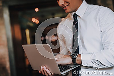 Close up smiling young man typing on laptop Stock Photo