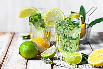 Concept of summer refreshing healthy alcohol free homemade lemonade with lemons, lime and tarragon. Low calories cold detox Stock Photo