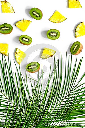 Concept of summer tropical fruits. Pineapple, kiwi and palm branch on white background top view Stock Photo