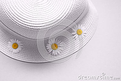 The concept of a summer vacation in the village. Panama and chamomile flowers on light background. Flat lay, top view. Stock Photo