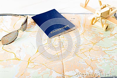 Concept of travelling, shopping, vacation, rest and relax. Cllose-up of map of roads, passport, sunglasses and wooden plane Stock Photo