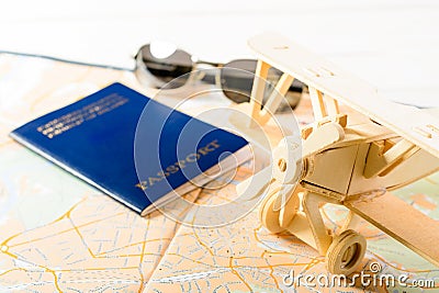 Concept of travelling, shopping, vacation, rest and relax. Selective focus on wooden airplane, on the background sunglasses, pass Stock Photo