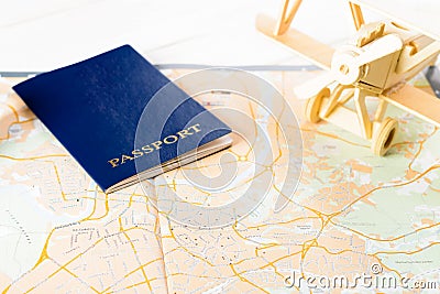 Concept of travelling, shopping, vacation, rest and relax. Selective focus on passport and wooden airplane laying on map of roads Stock Photo