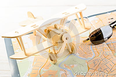 Concept of travelling, shopping, vacation, rest and relax. Selective focus on sunglasses and wooden airplane laying on map Stock Photo