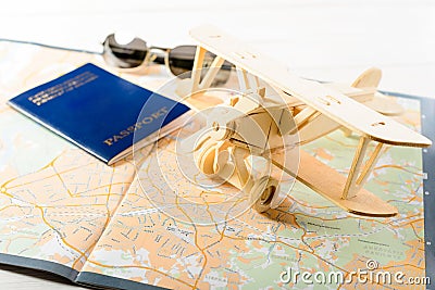 Concept of travelling, shopping, vacation, rest and relax. Selective focus on wooden airplane, on the background sunglasses, pass Stock Photo