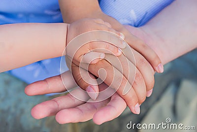 Concept of unity, support, protection, happiness. Child hand closeup into parents. Hands of father, mother, keep hand little baby Stock Photo