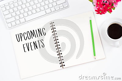 Concept Upcoming Events message on notebook, keyboard,with pencil and coffee cup. Top viwe of modern workplace. Stock Photo