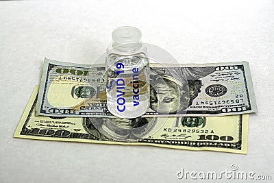 the concept of vaccination and business an ampoule with the inscription covid19 vaccine stands on banknotes on a white Stock Photo