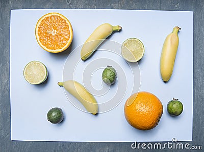 Concept vegetarian food, fresh appetizing fruit, lime, oranges, mini bananas, lined on blue background, vitamins, top view Stock Photo