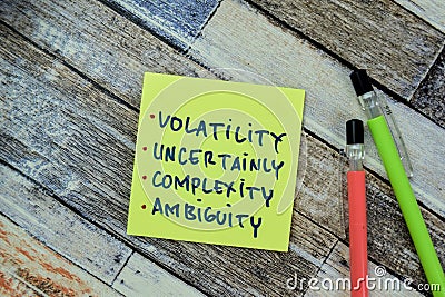 Concept of Volatility, Uncertainly, Complexity, Ambiguity write on sticky notes isolated on Wooden Table Stock Photo