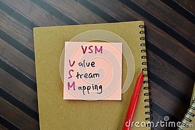 Concept of VSM - Value Stream Mapping write on sticky notes isolated on Wooden Table Stock Photo