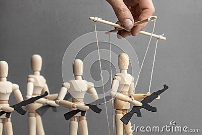 Concept of war. People with weapons, armed protest, terrorists. The puppeteer controls the doll with gun, the provoker Stock Photo