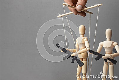 Concept of war. People with weapons, armed protest, terrorists. puppeteer controls the doll with gun, the provoker with weapons Stock Photo