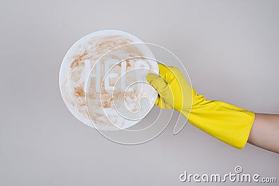 Concept of washing piles stack of dirty with left-overs cutlery. Side profile cropped close up photo of hand in protective rubber Stock Photo