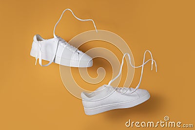 The concept of weightlessness and lightness. a pair of sneakers flying in the air on a yellow background Stock Photo