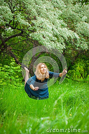 The concept of weightlessness. A woman in a blue dress flies Stock Photo