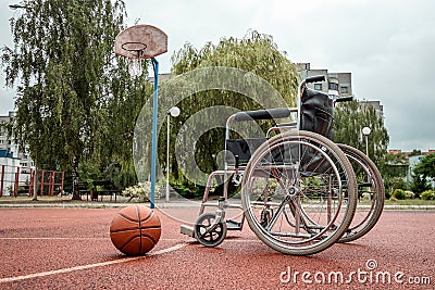 The concept of a wheelchair on the sports ground, a disabled person, a fulfilling life, paralyzed. Wheelchair on the basketball Stock Photo