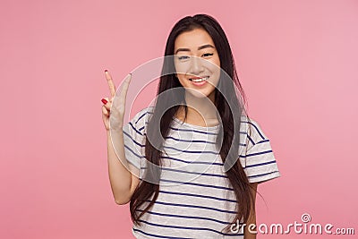 Concept of winning. Happy lucky joyful girl with long hair showing v sign, victory or peace hand gesture Stock Photo
