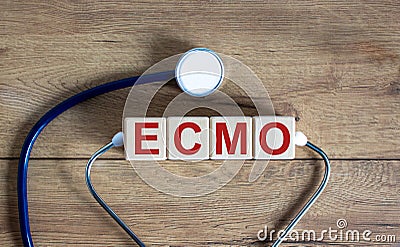 Concept word `ECMO, Extra Corporeal Membrane Oxygenation` on cubes on a beautiful wooden background. Stethoscope. Copy space, Stock Photo