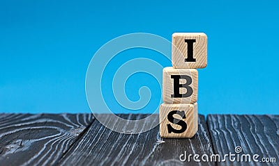 Concept word IBS on wooden cubes on a blue background Stock Photo