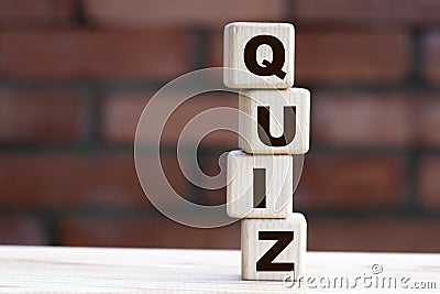 Concept word QUIZ on cubes against the background of a brick wall Stock Photo