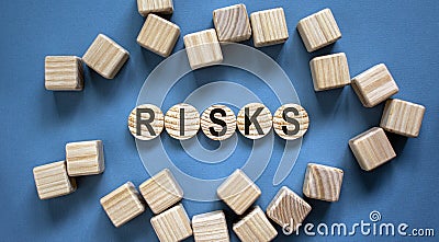 Concept word `risks` on woodwn circles on a beautiful blue background. Business concept Stock Photo