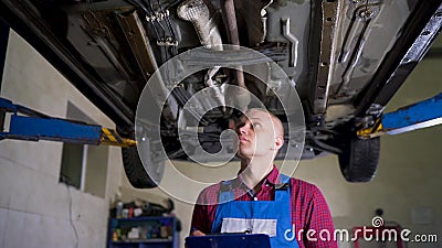 Concepto del servicio, de la reparación, del mantenimiento y de la gente del coche - el mecánico comprueba la calidad del trabajo almacen de metraje de vídeo Concepto del servicio, de la reparación, del mantenimiento y de la gente del coche - el mecánico comprueba la calidad del trabajo almacen de metraje de vídeo